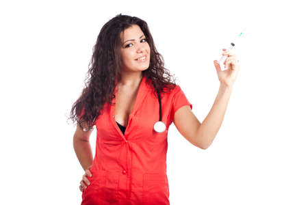 Sexy young nurse or medical woman doctor with big breasts, wearing tangerine tango orange uniform dress , smiling, holding syringe and looking at camera. Portrait isolated  on white background with text space. High resolution studio image.の写真素材