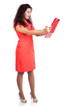 Beautiful professional young nurse or medical woman  doctor with big breasts, wearing tangerine tango orange uniform dress ,with clipboard  happy about results.  Full body isolated on white background with text space. High resolution studio image.の写真素材