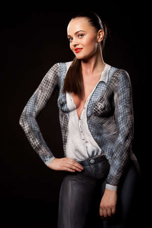 Artistic fashion concept of a businesswoman dressed in bodypaint office suit. Can be used for illustrating sexual issues at work. High resolution studio image on black background.の写真素材