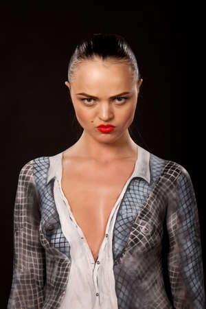Angry attractive young executive woman that has checkered businessuit painted on naked body. Artistic bodypainting concept for sexual issues at work.の写真素材