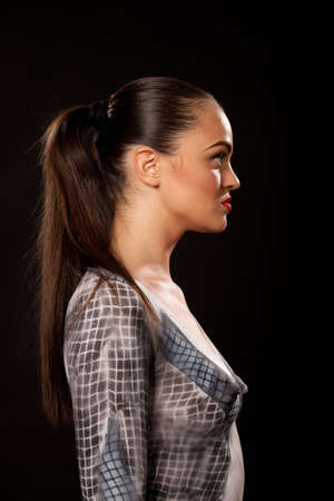 Profile of a serous attractive young executive woman that has checkered businessuit painted on naked body. Artistic bodypainting concept for sexual issues at work.の写真素材