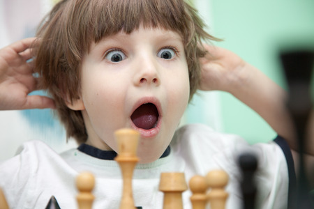 Portrait of a little boy playing chessの写真素材