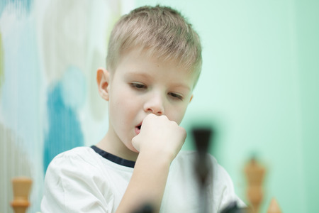 Portrait of a little boy playing chessの写真素材