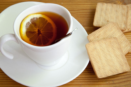 cup on saucer, biscuits and lemonの写真素材