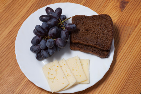 cheese, grapes and bread on the plateの写真素材