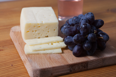 cheese and grapes on the wooden tableの写真素材