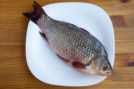 Fresh crucian fish on the wooden table