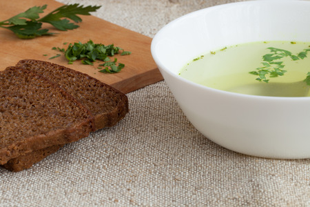Clear soup and bread on the natural burlapの写真素材