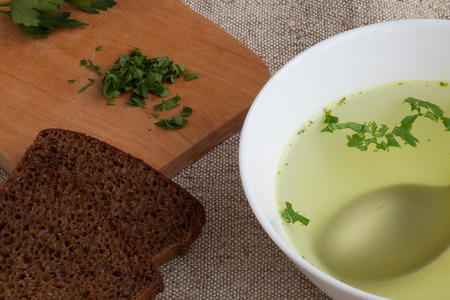 Clear soup and bread on the natural burlapの写真素材