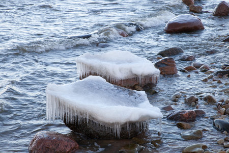 Winter landscape with ice on stones and sea