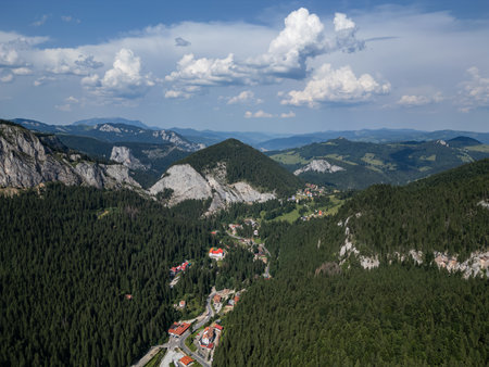 Aerial drone view of mountain valley with forest cliffs and small villageの写真素材