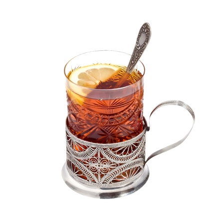 Tea glass with a lemon in a  glass-holder  isolated on a white backgroundの写真素材