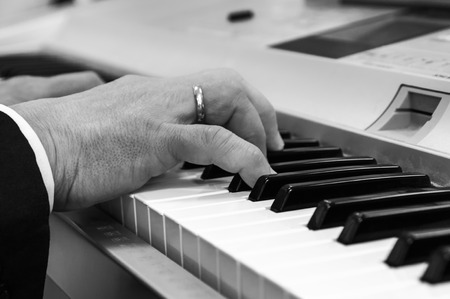 Hands on the keys of a piano Piano selective focus on the fingers and the keysの写真素材