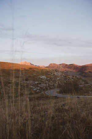 mountain landscape at sunset you can see the road in the grassの写真素材