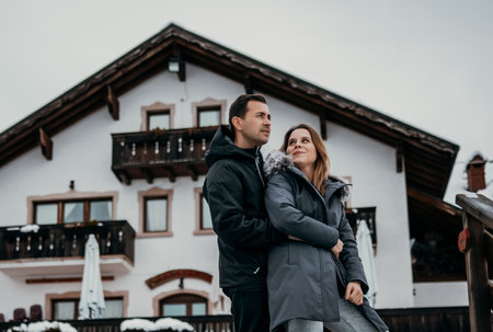 a couple embracing on a mountain house background look to the sideの写真素材