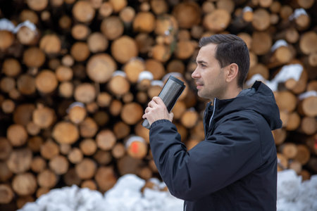 a guy drink a hot the in the snow street mountain with snow