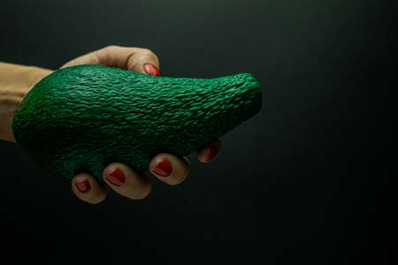 woman hand holding avocado Isolated on black backgroundの写真素材