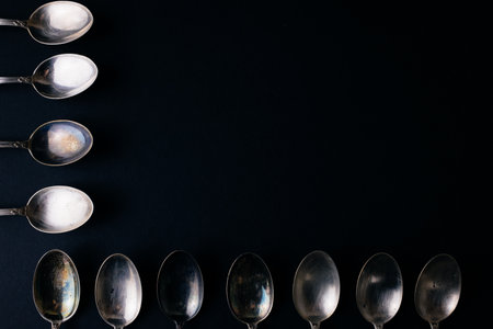 Vintage silver spoons on the black background, copy spaceの写真素材