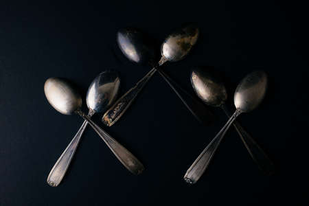 Vintage silver spoons on the black background, copy spaceの写真素材