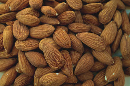 Background of big raw peeled almonds situated arbitrarilyの写真素材