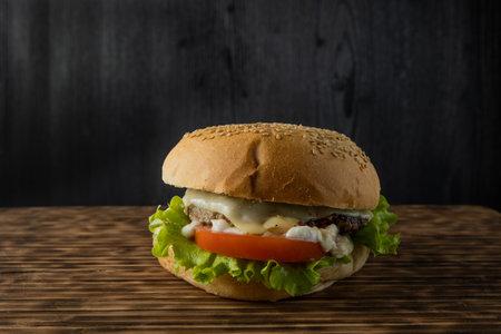 burger with lettuce and mayonnaise served on a rustic wooden table , with copyspaceの写真素材