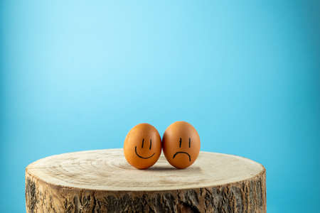 funny eggs with face feeling on the wooden tableの写真素材