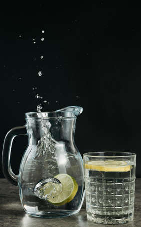 splash of water in a decanter with lemon, black background, copy spaceの写真素材