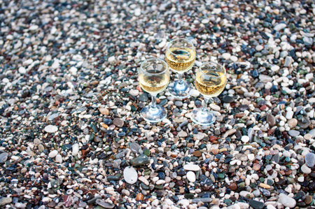 three glasses of white wine on the beach on sammer