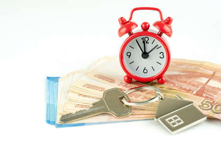 house key and red alarm clock, the concept of a home purchaseの写真素材