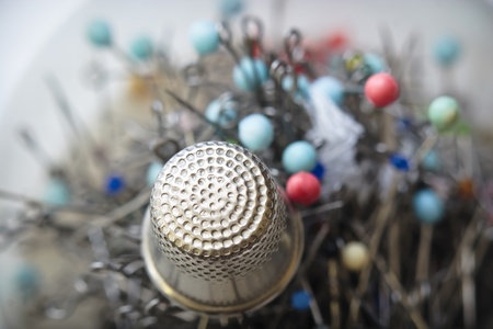 Thimble and pins;red, blue and green heads of pinsの写真素材