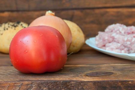 Ingredients for hamburger, cooking at home, fresh food on the table: tomato, minced meat, saladの写真素材