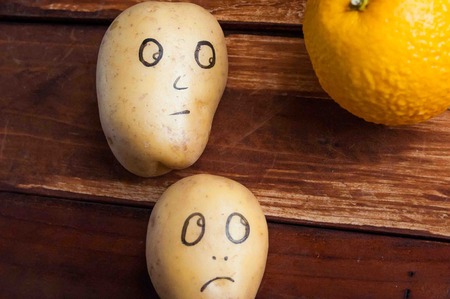 eyes painted potato looking at fruitの写真素材