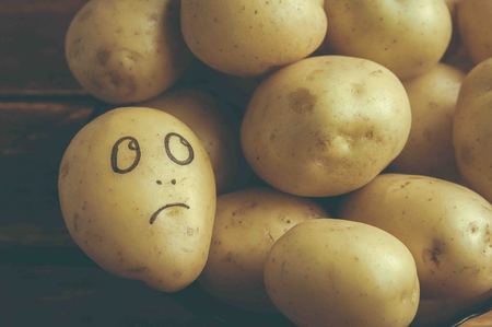 eyes painted potato looking at fruitの写真素材