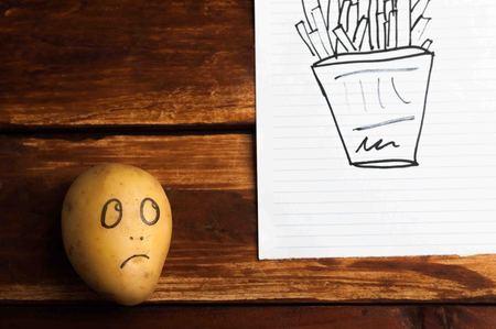 eyes painted potato looking at fruitの写真素材