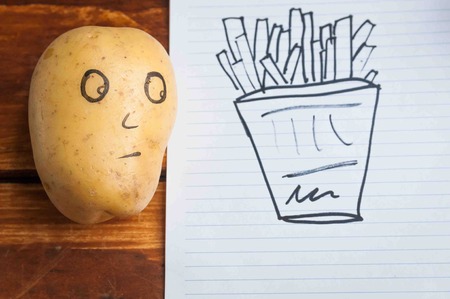 eyes painted potato looking at fruitの写真素材