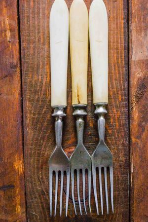 cutlery on the table, old forks on the background of old oakの写真素材