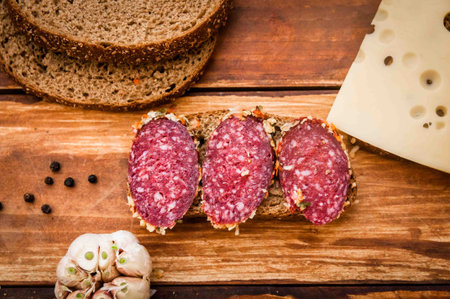 Sausage cooked smoked Cervelat, cheese with dark for breakfast on the table, sausage seasoning,...