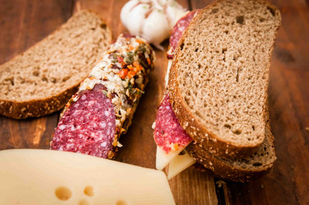 Sausage for breakfast, black bread, garlic, black pepper, bay leaf on the tableの写真素材