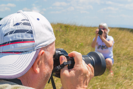 two photographers, a female photographer takes pictures of a male photographerの写真素材