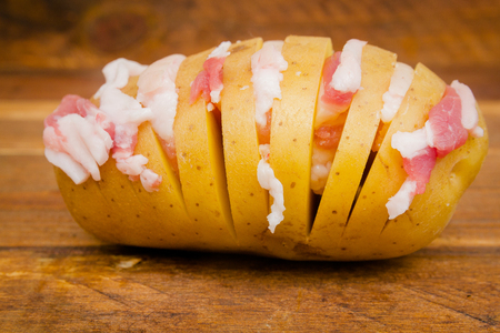 yellow sliced potatoes with bacon for cooking in the ovenの写真素材