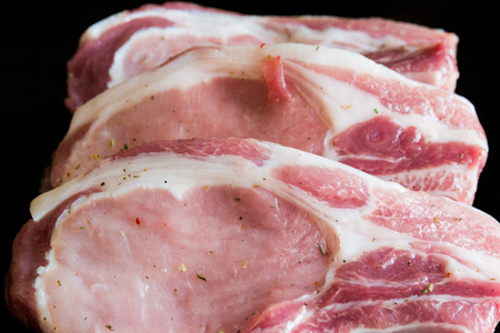 pork roast seasoned with salt and black pepper, tomatoes and fresh greensの写真素材