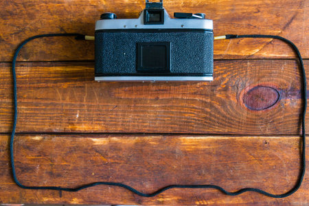 old silver camera with black plastic on a wooden background