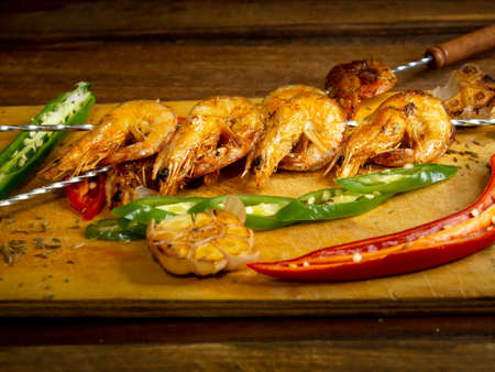 Delicious fried prawns on a skewer with sauce and lemonの写真素材