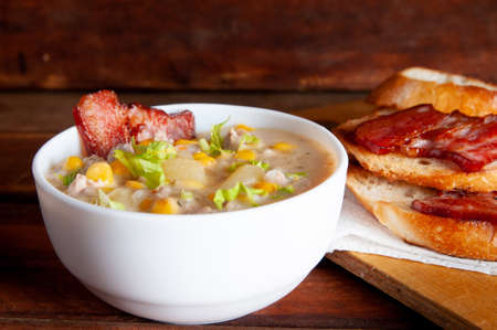 Corn chowder soup with bacon. Brown wooden background. Close-up viewの写真素材