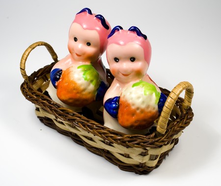 Bast basket with saltcellar and pepperbox in the form of a ladybird with a strawberryの写真素材