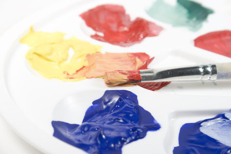 White palette with mixed paints and paintbrushの写真素材