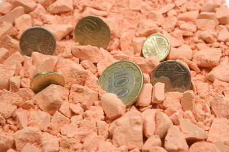 Several coins in orange crushed chalk background
