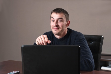 Portrait of a young business man standing with laptopの写真素材