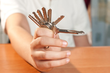 hand holds a gold key (key in focus) 