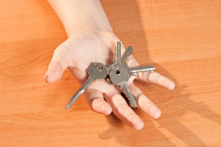 hand holding a key on a brown backgroundの写真素材